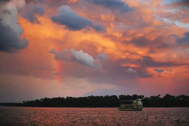 A rainbow is seen behind a ferry on Lake Ontario in front of Toronto Island, July 8, 2014. (Photo by Mark Blinch/Reuters)