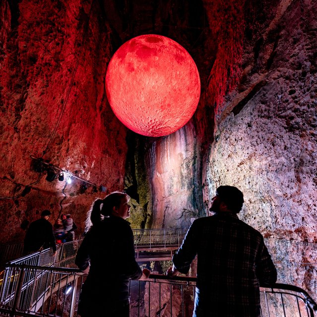 A couple look around Chamber 9 inside Wookey Hole caves, near Wells in Somerset, UK where a giant 5m wide blood moon hangs from the roof of the cave as part of Wookey Hole's annual celebration of Halloween events on Sunday, October 6, 2024. (Photo by Ben Birchall/PA Images via Getty Images)