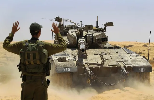 An Israeli soldier directs a tank maneuvering near the border between Israel and Egypt on June 18, 2012