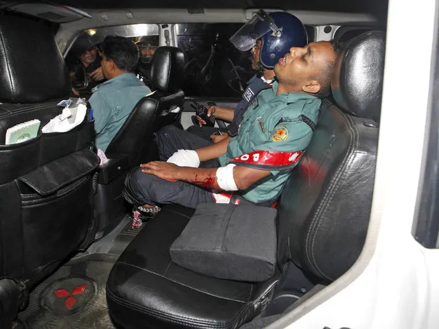 An injured police officer sits in a car after suffering wounds from a crude bomb blasted by suspected criminals at a Spanish resturant in Dhaka, Bangladesh, late 01 July 2016. Two police officials have been killed during the encounter while some gunmen reportedly took several people hostage, including some foreigners, inside a Spanish resturant. The law inforcement officials try to negotiate with the gunmen while the US-based SITE Intelligence Group quoted the Amaq News Agency as saying that fighters of the terrorist organisation “Islamic State” (IS) carried out the attack. (Photo by EPA/Stringer)