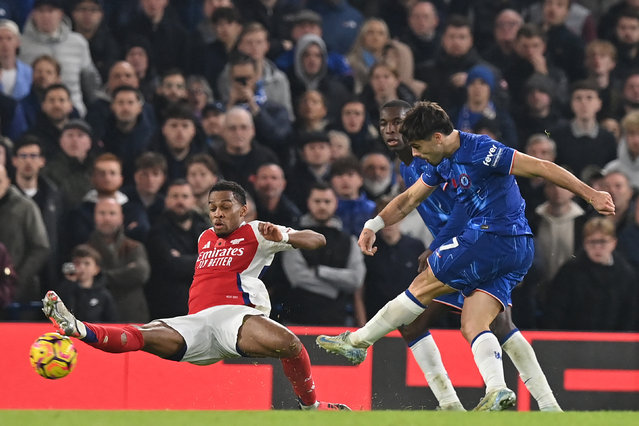 Chelsea's Portuguese midfielder #07 Pedro Neto (R) shoots to score their first goal during the English Premier League football match between Chelsea and Arsenal at Stamford Bridge in London on November 10, 2024. (Photo by Glyn Kirk/AFP Photo)