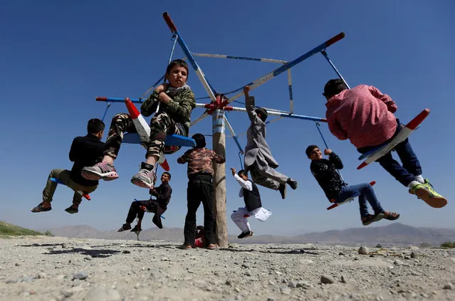 Afghan children ride on a swing on the first day of the holiday in Kabul, Afghanistan on September 1, 2017. (Photo by Mohammad Ismail/Reuters)