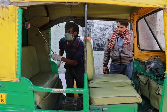 A worker disinfects an autorickshaw as part of a preventive measure against coronavirus, in New Delhi, India, March 17, 2020. (Photo by Anushree Fadnavis/Reuters)