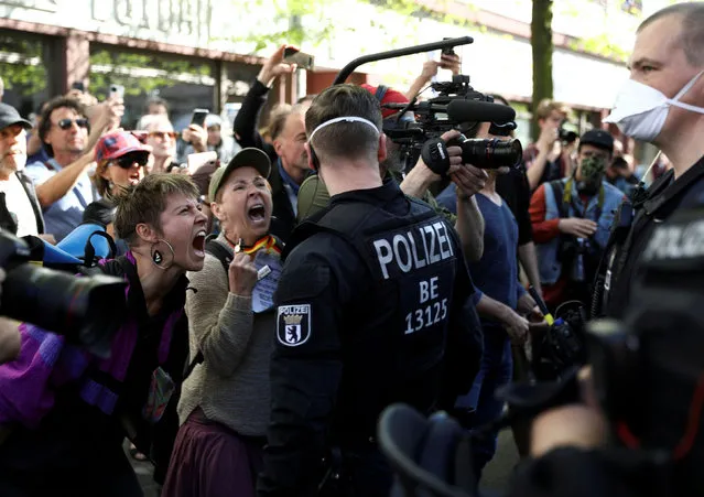 People shout at police officers during a demonstration of conspiracy theorists as other demonstrators protest against the lockdown imposed to slow the spread of the coronavirus disease (COVID-19), in Berlin, Germany, April 18, 2020. (Photo by Christian Mang/Reuters)