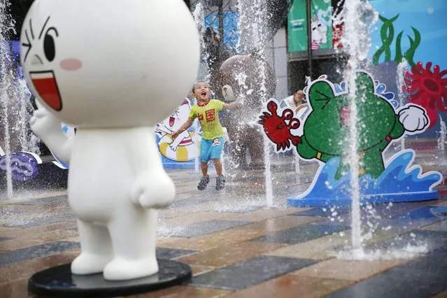 A Chinese boy wearing a T-shirt with Chinese words “China” plays among pop ups of 'Line Friends', characters of emojis from Japanese chat application Line in a shopping mall in Beijing, China, 11 August 2014. (Photo by How Hwee Young/EPA)