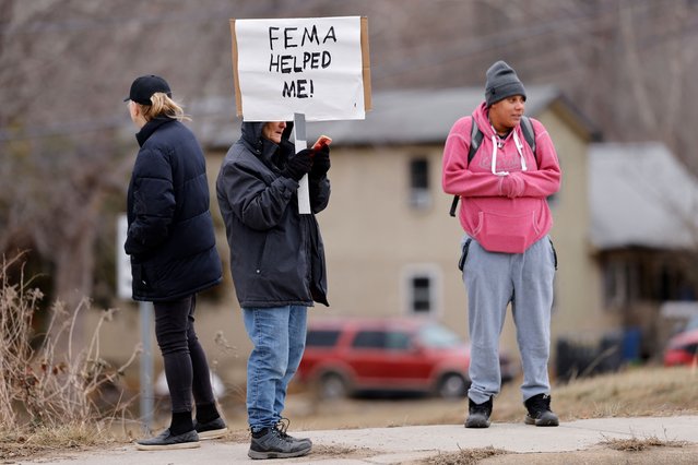 Swannanoa resident Lucy Bickers, who received assistance from FEMA after Hurricane Helene damaged her property, holds a sign in support of the government agency as she waits on the route of visiting U.S. President Donald Trump's motorcade in Swannanoa, North Carolina, U.S., January 24, 2025. (Photo by Jonathan Drake/Reuters)