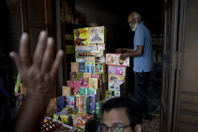 An Indian shopkeeper arranges boxes of fire crackers in New Delhi, India, Monday, October 9, 2017. India's Supreme Court has banned the sale of fireworks in New Delhi and nearby towns, 10 days before the Hindu festival of Diwali, in a move to curb the capital's deadly air pollution. (Photo by Tsering Topgyal/AP Photo)