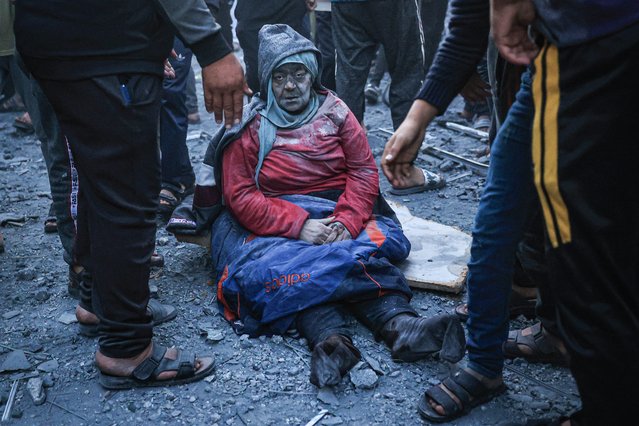 A woman injured in an Israeli strike sits amid the rubble in Rafah in the southern Gaza Strip on December 3, 2023, amid continuing battles between Israel and the militant group Hamas. Israel carried out deadly bombardments in Gaza on December 3 as international calls mounted for greater protection of civilians and the renewal of an expired truce with Palestinian militant group Hamas. (Photo by Said Khatib/AFP Photo)