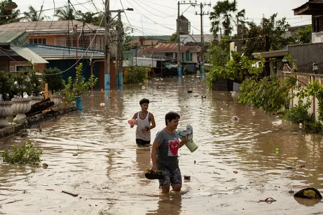 Residents wade through waist-deep flood waters after Super Typhoon Noru, in San Miguel, Bulacan province, Philippines on September 26, 2022. (Photo by Eloisa Lopez/Reuters)