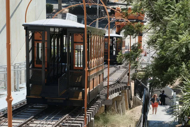 This Monday, August 28, 2017, photo a pedestrian makes her way up a steep flight of stairs next to the Angels Flight railroad in downtown Los Angeles. The little funicular that carried Emma Stone and Ryan Gosling to the top of downtown Los Angeles in the movie “La La Land” is scheduled to reopen to the general public Thursday. (Photo by Richard Vogel/AP Photo)