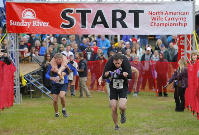 Contestants leave the starting line to compete in the North American Wife Carrying Championship at Sunday River ski resort in Newry, Maine October 11, 2014. REUTERS/Brian Snyder