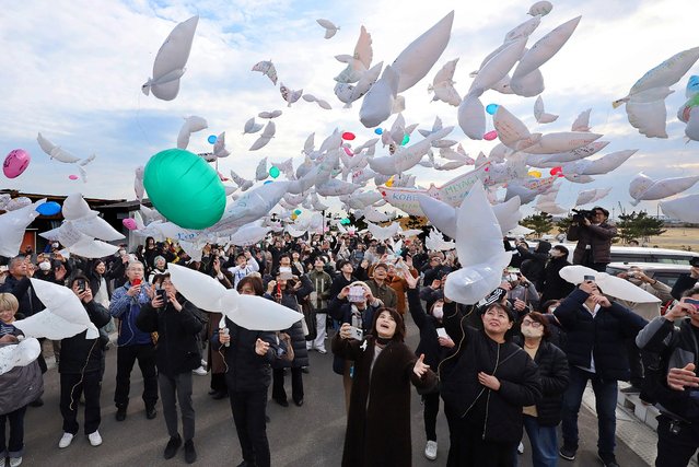 People release dove-shaped balloons in the air in remembrance in Natori, Miyagi Prefecture, on March 11, 2025, to mark the 14th anniversary of the magnitude 9.0 earthquake which triggered a tsunami and nuclear disaster. (Photo by JIJI Press/AFP Photo)