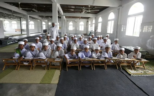 Tahfiz or Koranic students pose for a photograph in Madrasah Nurul Iman boarding school outside Malaysia's capital city, Kuala Lumpur September 11, 2015. There are 36 male students at the madrasah, ranging from 11 to 18 years of age. (Photo by Olivia Harris/Reuters)