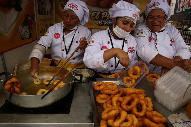 Cook serve traditional dessert “Picarones” during Mistura gastronomic fair, which promotes Peruvian cuisine by showcasing food and products from all over the country, in Lima, Peru, September 8, 2016. (Photo by Mariana Bazo/Reuters)