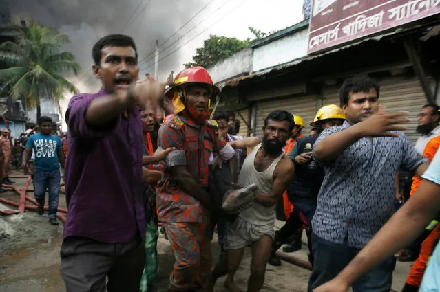 A Bangladeshi rescue worker and a volunteer carry the body of a victim from the site of an explosion in a factory in the key Bangladeshi garment manufacturing town of Tongi, just north of the capital Dhaka, on September 10, 2016. (Photo by AFP Photo/Stringer)