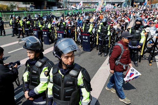 Members of the police stand guard next to reacting far-right protesters after President Yoon Suk Yeol's impeachment was accepted, near his residence in Seoul, South Korea, on April 4, 2025. (Photo by Kim Soo-hyeon/Reuters)
