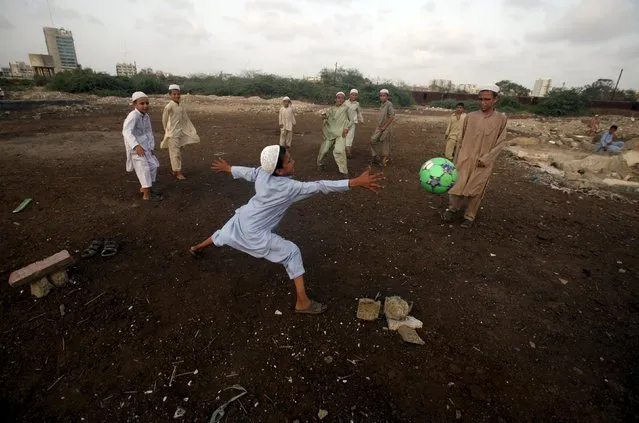 Madrasa (religious school) students play soccer on the grounds of a slum in Karachi, Pakistan, August 28, 2015. (Photo by Athar Hussain/Reuters)