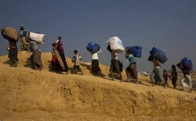 In this Sunday, January 21, 2018, photo, Rohingya refugees who are being relocated from a camp near the Bangladesh Myanmar border arrive at Balukhali refugee camp 50 kilometres (31 miles) from, Cox's Bazar, Bangladesh. With the first repatriations of Rohingya refugees back to Myanmar just days away, and more than 1 million living in refugee camps in Bangladesh, international aid workers, local officials and the refugees say preparations have barely begun  and most refugees would rather contend with the squalor of the camps than the dangers they could face if they return home. It's unclear if more than a handful of Rohingya will even be willing to go home. (Photo by Manish Swarup/AP Photo)