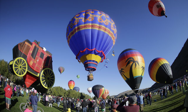Hot air balloons are inflated and lift off during the Autumn Aloft Hot Air Balloon Festival Saturday, September 17, 2016, in Park City, Utah. (Photo by Rick Bowmer/AP Photo)