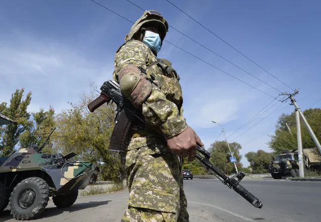 Soldiers of Kyrgyz army stand at checkpoint on city street in Bishkek, Kyrgyzstan, Saturday, October 10, 2020. President Sooronbai Jeenbekov decreed the state of emergency in the capital and ordered the military to deploy troops to Bishkek to enforce the measure. (Photo by Vladimir Voronin/AP Photo)