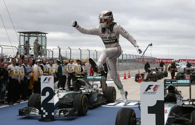 Mercedes Formula One driver Lewis Hamilton of Britain leaps off of his car after winning the U.S. F1 Grand Prix at the Circuit of The Americas in Austin, Texas October 25, 2015. Hamilton clinched his third Formula One world championship on Sunday after winning a thrilling and unpredictable U.S. Grand Prix for Mercedes. (Photo by Adrees Latif/Reuters)