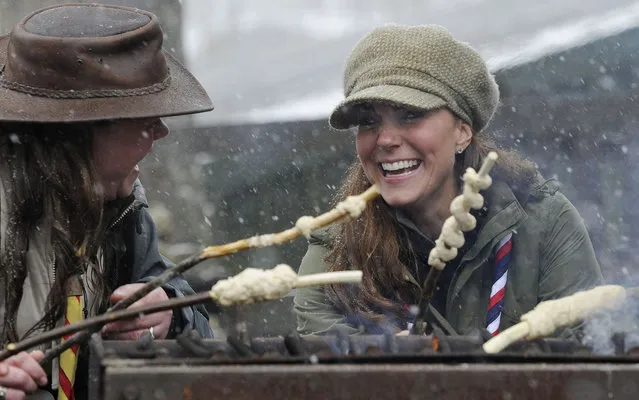 Catherine, Duchess of Cambridge joins in the preparation of campfire food during a visit to the Great Tower Scout camp at Newby Bridge in Cumbria on March 22, 2013.   The Duchess braved snowy conditions to pay a visit to the scout camp. (Photo by Andy Stenning/AFP Photo)