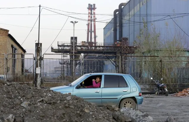 A local man sits in a car outside a closed steel factory on the outskirts of Jixi in Heilongjiang province, China, October 22, 2015. Profits earned by Chinese industrial companies fell 0.1 percent in September from a year earlier, data from the statistics bureau showed on Tuesday, leveling after a record 8.8 percent collapse in August. (Photo by Jason Lee/Reuters)