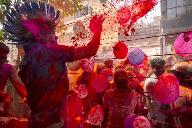 People celebrate Holi, the festival of colors on a street in Guwahati, India, Wednesday, March 8, 2023. (Photo by Anupam Nath/AP Photo)