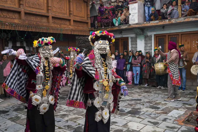 Men dressed in traditional costume perform a dance called Raulaane at an old Hindu temple in Kalpa, India, Monday, March 13, 2023. Locals perform this dance to bid farewell to the mountain deities who they believe return to the mountain peaks in spring. (Photo by Ashwini Bhatia/AP Photo)