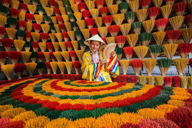 A view of colorful incenses, traditionally produced at the Thuy Xuan Incense-making Village, in the central province of Thua Thien Hue, Vietnam on July 06, 2025. The village has been preserving the tradition of incense making for over 700 years. Once producing incense for royal palaces and local communities, the village has now become a popular destination for both domestic and international visitors. The incense sticks, made from natural ingredients such as agarwood, cinnamon, clove, and pine resin, stand out for their pure aromas free from chemical additives. After the bamboo sticks are sun-dried, a natural mixture is carefully applied, creating incense used in both religious rituals and daily life. The colorful bundles of incense sticks left to dry in the villagefeaturing dominant shades of green, red, purple, and yellowresemble a vibrant flower garden. Tourists visiting the village can observe the entire production process, from drying the bamboo sticks in the sun to applying the mixture, and even try making their own incense if they wish. (Photo by Ummu Nisan Kandilcioglu/Anadolu via Getty Images)