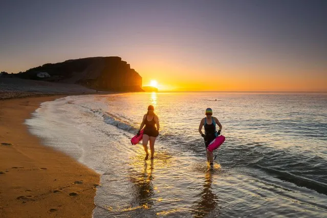 Swimmers brave the freezing temperatures as they emerge from the sea at sunrise after taking an early morning dip at West Bay in Dorset, UK on a cold clear frosty morning on February 7, 2023. (Photo by Graham Hunt/Alamy Live News)