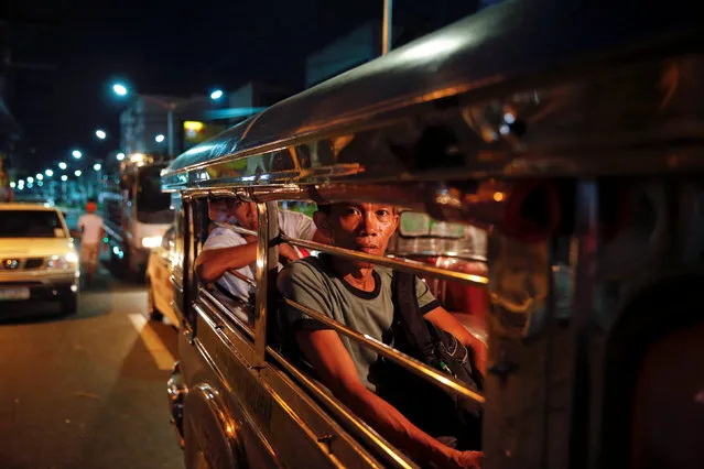People look from inside a jeepney as police investigate around the body of a man killed by unknown gunmen in Manila, Philippines early October 18, 2016. (Photo by Damir Sagolj/Reuters)