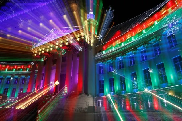 In this Monday, December 22, 2014, photo taken with a slow shutter, the Denver City/County building is illuminated by the traditional holiday light display, in Denver. The holiday lights will burn each evening through New Year's Eve and then resume for the annual run of the National Western Stock Show and Rodeo. (Photo by David Zalubowski/AP Photo)