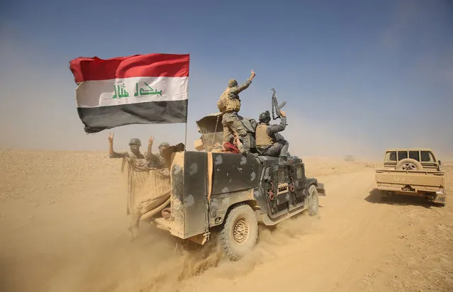 Iraqi forces deploy in the Bajwaniyah village, about 30 kms south of Mosul, on October 18, 2016 after they liberated it from Islamic State (IS) group jihadists. Tens of thousands of Iraqi forces were making gains on the Islamic State group in Mosul in an offensive US President Barack Obama warned would be a “difficult fight”. (Photo by Ahmad Al-Rubaye/AFP Photo)