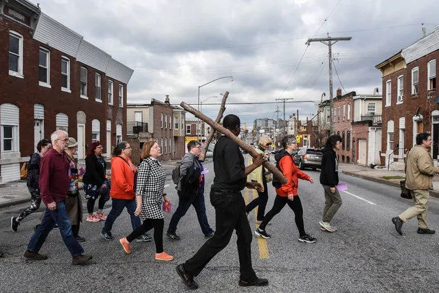 Community members carry a wooden cross on Good Friday to locations where people were killed by gun violence in Baltimore, Md., March 30, 2018. (Photo by Stephanie Keith/Reuters)