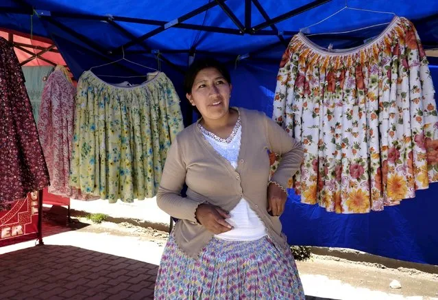 An artisan stands at the fair of the Cholita fashion show at Villa Esperanza in El Alto, on the outskirts of La Paz, November 18, 2015. (Photo by David Mercado/Reuters)