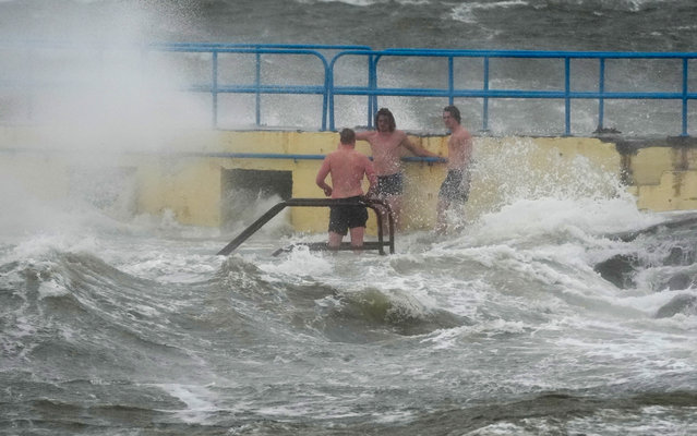 People on Blackrock diving tower in Salthill, Galway, UK on Friday, October 3, 2025. Storm Amy will bring damaging winds to the island of Ireland with every county under weather warnings on Friday. Wind speeds could reach up to 80mph (130km/h) along the most exposed coastal areas of the island, with fallen trees and power outages among the potential impacts. (Photo by Brian Lawless/PA Images via Getty Images)