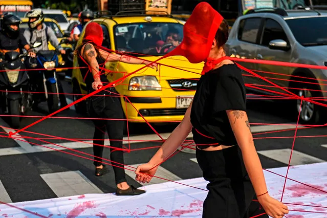 Colombian activists perform during a protest against violence towards women, on a street in Medellin, Colombia, on March 6, 2020. (Photo by Joaquín Sarmiento/AFP Photo)