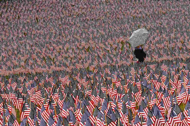 A pedestrian carrying an umbrella walks through a Memorial Day display of United States flags on the Boston Common in Boston, Massachusetts May 23, 2013.  According to the Massachusetts Military Heroes Fund, the flags are planted on the Common for fallen Massachusetts service members at the Memorial Day holiday, which will be celebrated May 27 in the U.S. (Photo by Brian Snyder/Reuters)