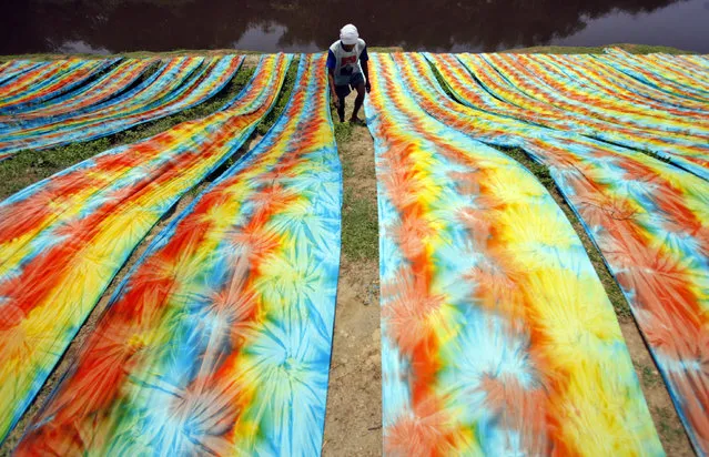 An Indonesian worker dries coloured fabrics on a riverbank in Sukoharjo, Central Java, Indonesia, 24 November 2015. Indonesia's economy grew 4.73 per cent in the third quarter of 2015, higher than the second quarter of 2015 which was 4.67 per cent, the Central Statistics Agency (BPS) reported. (Photo by Ali Lutfi/EPA)