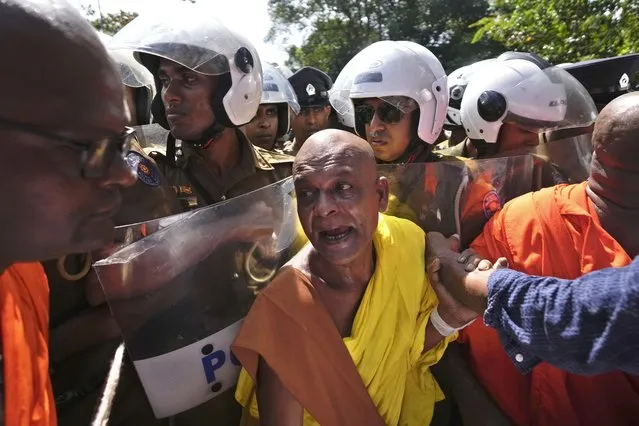 A Sri Lankan Buddhist monk scuffles with policemen outside the parliament during a protest against president Ranil Wickremesinghe's policy speech at the parliament in Colombo, Sri Lanka on Wednesday, February 8, 2023. Wickremesinghe on Wednesday appealed for patience amid the country's worst economic crisis but promised brighter times ahead. (Photo by Eranga Jayawardena/AP Photo)