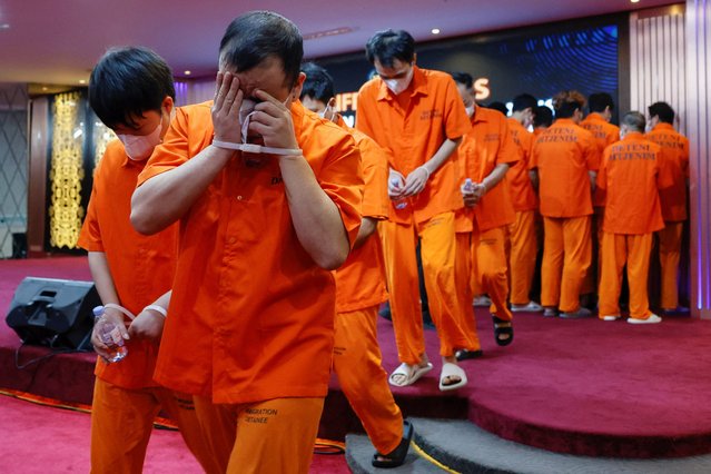 Cybercrime suspects from China walk after a press conference regarding the arrest of Chinese nationals, following Indonesian authorities' deportation of suspects wanted by Chinese authorities for alleged financial crimes, along with 27 Chinese nationals accused of scamming, in Jakarta, Indonesia, on November 18, 2025. (Photo by Ajeng Dinar Ulfiana/Reuters)