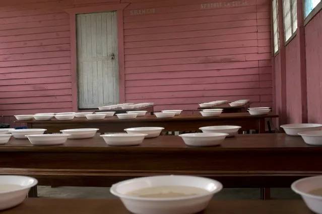 In this November 18, 2015 photo, bowls of rice pudding, provided by the state food program for public schools, await for the morning arrival of students in Potsoteni, an Ashaninka indigenous community in Peru's Junin region. One of the government programs aims at school children, bringing food to a little over 3,000 students in communities along the Ene River basin. (Photo by Rodrigo Abd/AP Photo)