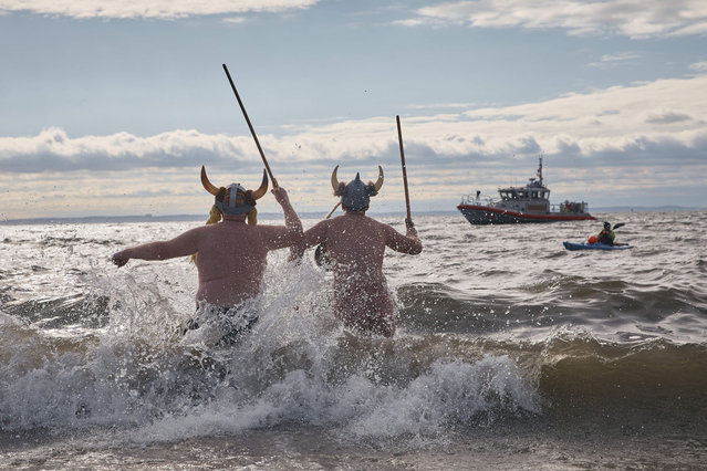 Revelers in a costume enter the cold water during the annual Polar Bear Plunge on New Year's Day, Wednesday, January 1, 2025, in New York. (Photo by Andres Kudacki/AP Photo)