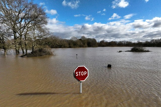 A road sign rises above the water as severe flooding hits western France amid storm Ivo, Thursday, January 30, 2025 in Redon, western France. (Photo by Thibault Camus/AP Photo)