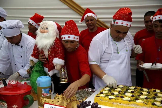Inmates prepare food during a Christmas event at Sarita Colonia male prison in Callao, Peru, December 18, 2015. (Photo by Mariana Bazo/Reuters)