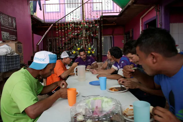 Immigrants eat at the premises of a group called “Las Patronas” (The bosses), a charitable organization that feeds Central American immigrants on their way to the border with the United States who travel atop a freight train known as “La Bestia”, in Amatlan de los Reyes, in Veracruz state, Mexico October 22, 2016. (Photo by Daniel Becerril/Reuters)