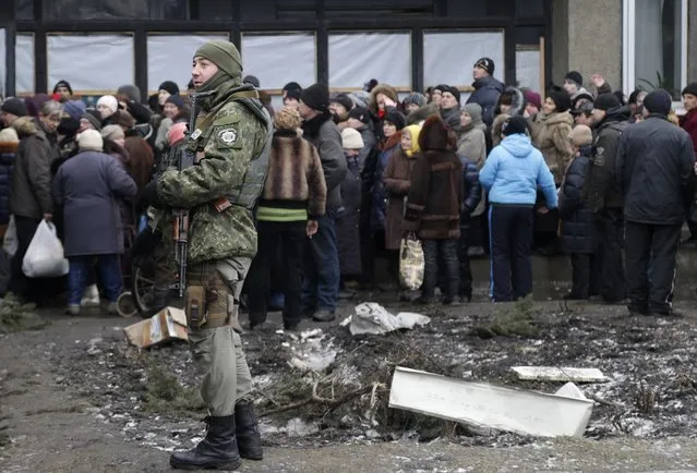 Soldier stands guard as humanitarian aid is distributed to residents in the town of Debaltseve, Ukraine, Friday, February 6, 2015. (Photo by Petr David Josek/AP Photo)
