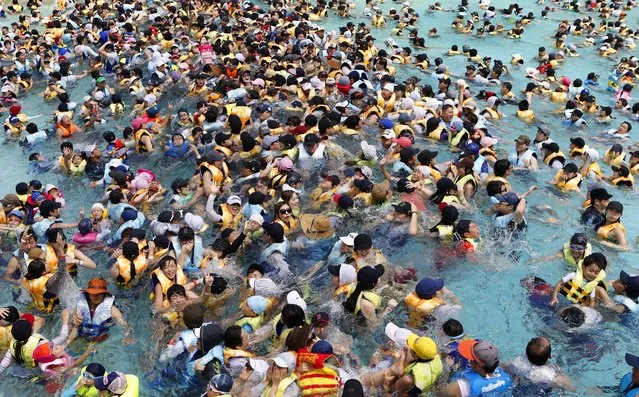 People escape the heat at the Caribbean Bay swimming pool in South Korea's largest amusement park, Everland, in Yongin, on August 11, 2013. South Korea has been suffering from the sweltering heat wave for weeks with temperatures in most parts of the country soaring above 95 degrees Fahrenheit. (Photo by Lee Jae-Won/Reuters)