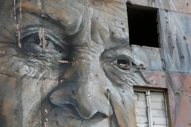 Bullet holes on a mural after the shelling by Russia-backed rebels in Avdiivka, Donetsk region, eastern Ukraine, Friday, April 16, 2021. Growing cease-fire violations and a massive Russian military buildup are causing tensions to rise in the conflict in eastern Ukraine. Ukraine and the West have become increasingly worried about the presence of more Russian troops near the border with its neighbor and urged Moscow to pull them back. More than 14,000 people have died in seven years of fighting between forces from Kyiv and separatists loyal to Moscow. (Photo by Efrem Lukatsky/AP Photo)